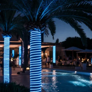 Manguera LED neón azul ice instalada decorando palmeras en jardín exterior nocturno